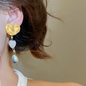 Detailed view of vintage irregular yellow heart tassel earrings on model ear lobe