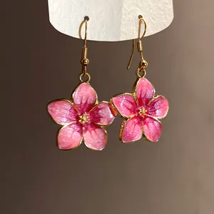 Detailed close-up showing the pink gradient petals and glittery texture of flower earrings