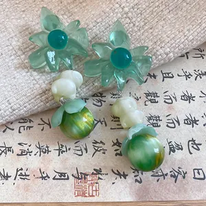 Detailed view of sweet green flower drop earrings with marbled bead accents