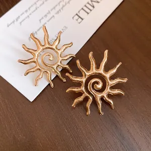 Detailed macro view of golden sun-shaped hollow metal stud earrings