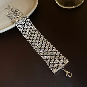 Vue rapprochée d'un large bracelet en strass argenté à plusieurs rangées de cristaux