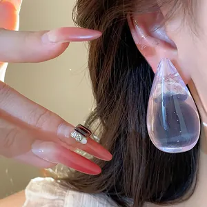 Vista detallada de elegantes pendientes de gota de resina portados por una modelo