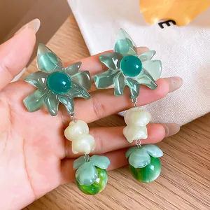 Detailed shot of green translucent resin flower pendant earrings in a summer vacation style