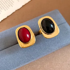 Elegant vintage gold-plated square open rings with red and black oval gemstones.