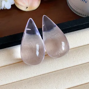 Primer plano detallado de pendientes de gota en resina lavanda traslúcida en bandeja