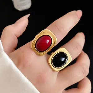 Elegant vintage gold-toned square open rings featuring red and black oval stones