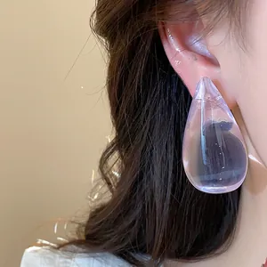Primer plano de un pendiente de gota de resina púrpura transparente grande