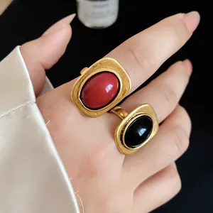 Detail shot of elegant vintage gold open rings featuring red and black oval stones