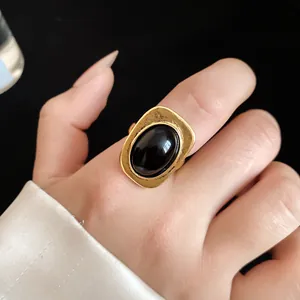 Detail view of a vintage gold-plated open ring featuring a large black oval onyx stone