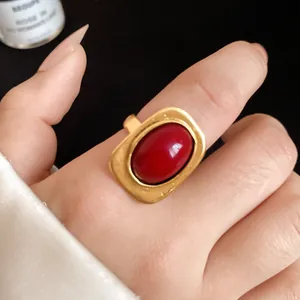 Macro detail of a vintage gold-tone open ring with a large red oval stone