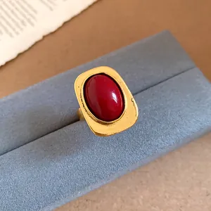 Detailed view of a vintage-style gold ring featuring a prominent red oval cabochon stone.