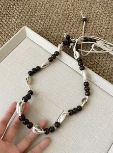 Nahaufnahme einer Boho-Taillenkette mit Holzperlen und natürlichen Muschelelementen.