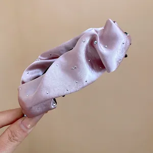 Primo piano dettagliato del fermaglio a banana in raso rosa con strass lucidi