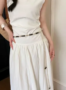 Detailansicht einer böhmischen braunen Perlen-Taillenkette auf einem weißen Sommerkleid