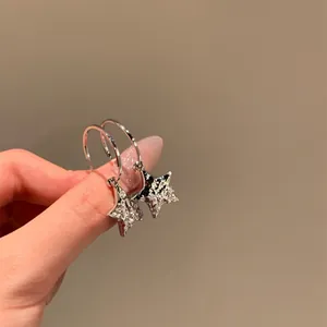 Close-up view of silver Y2K style star hoop earrings with sparkling rhinestone details
