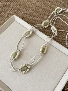 Nahaufnahme einer geflochtenen Bohemian-Taillenkette mit grünen Perlen und Akzenten aus Seil