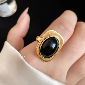 Detail shot of vintage gold adjustable ring featuring a polished black oval stone