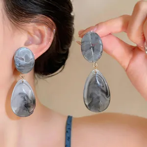 Detailed close-up of grey marble resin teardrop earrings with elegant gold accents