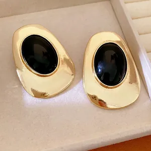 Vintage gold-toned earrings with large oval black stone inserts for luxury style