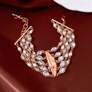 Vista dettagliata di un elegante bracciale in oro multistrato con strass e labbra