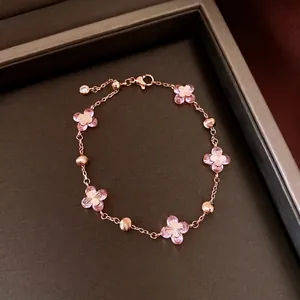 Vintage rose gold bracelet with pink zircon flower charms in a jewelry box