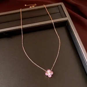 Elegant rose gold necklace with pink zircon flower pendant on a dark jewelry tray.