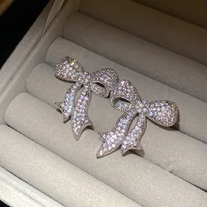 Primer plano de pendientes de lazo con circonitas brillantes en joyero de terciopelo