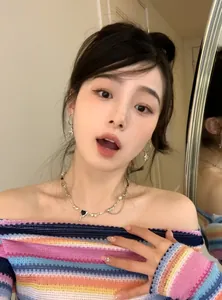 Close-up of Y2K star earrings and heart necklace on model in colorful knit top