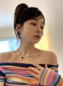 Detailed shot of a model wearing Y2K style star earrings and heart pendant necklace