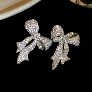 Primer plano de elegantes pendientes de lazo con circonitas brillantes y estilo.