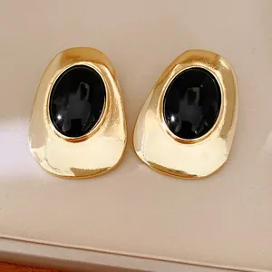 Elegant vintage gold-tone stud earrings with oval black center stones, detail view