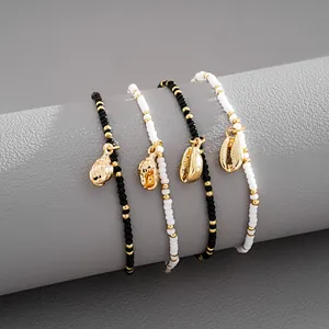 Close-up detail of elegant handmade beaded bracelet set with gold seashell charms