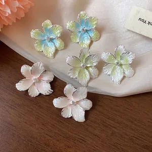 Boucles d'oreilles fleurs en zircon coloré avec finition émail sur fond de tissu