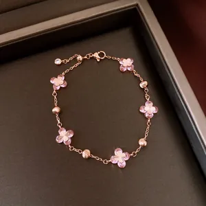 Elegant rose gold bracelet featuring pink zircon flowers and metallic beads in a box