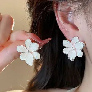 Boucles d'oreilles fleurs blanches élégantes avec zircon et finition huile texturée