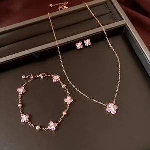 Macro view showing a rose gold jewelry set featuring elegant pink zircon flower charms.