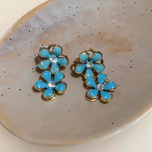 Elegant tiered blue enamel flower stud earrings with sparkling rhinestone centers