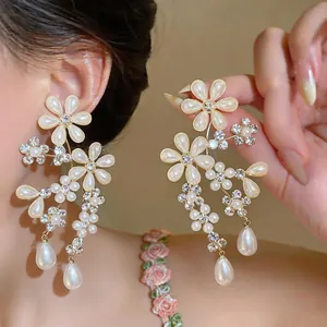 Detail of elegant French palace style earrings with crystal flowers and pearl drops.