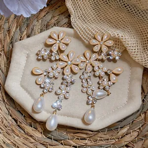 Detail view of French court style pearl earrings with crystal flowers and teardrop drops