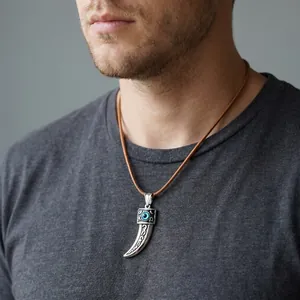 Close-up of punk stainless steel wolf fang pendant with a blue evil eye detail