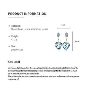 Macro view of vintage heart earrings with blue rhinestones and product measurements