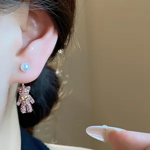 Detaillierte Makroansicht eines rosa Bären-Ohrrings mit Strass und Perlenstecker