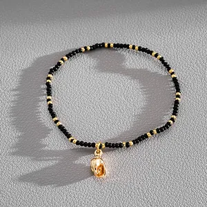 Elegant black and gold beaded bracelet with a vintage-style gold seashell charm pendant