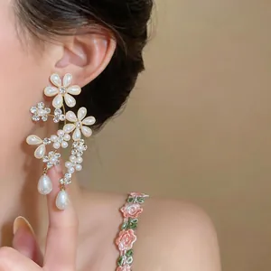 Elegant French style floral pearl drop earrings with rhinestones worn for detail view