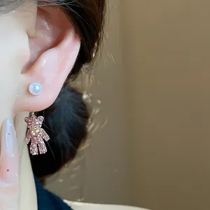 Detailansicht eines modischen Ohrsteckers mit rosa Strassbär und Perle aus Silber