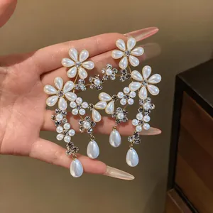 Elegant French style floral pearl drop earrings with sparkling rhinestone details.