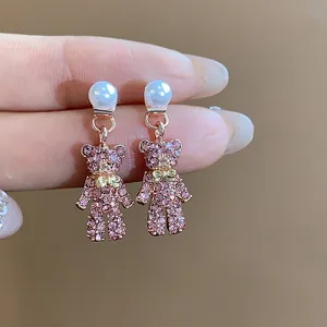 Detailaufnahme der rosa Bären-Ohrringe mit Strass und eleganten Perlensteckern