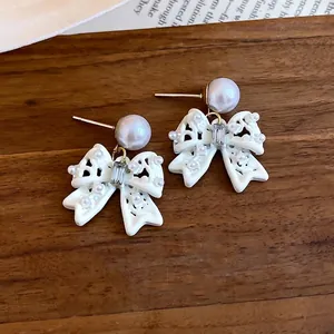 Eleganti orecchini a fiocco bianco traforato in stile francese con perle e cristalli