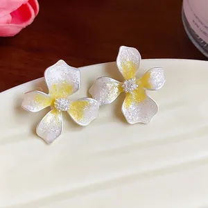 Detailed close-up of elegant flower earrings featuring white petals and yellow centers