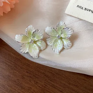 Détail de boucles d'oreilles fleur élégantes en émail vert citron et zircone